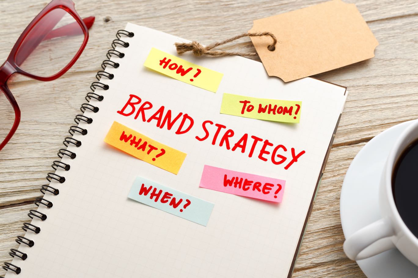 Brand marketing strategy concept with notebook, brand tag and coffee cup on office desk